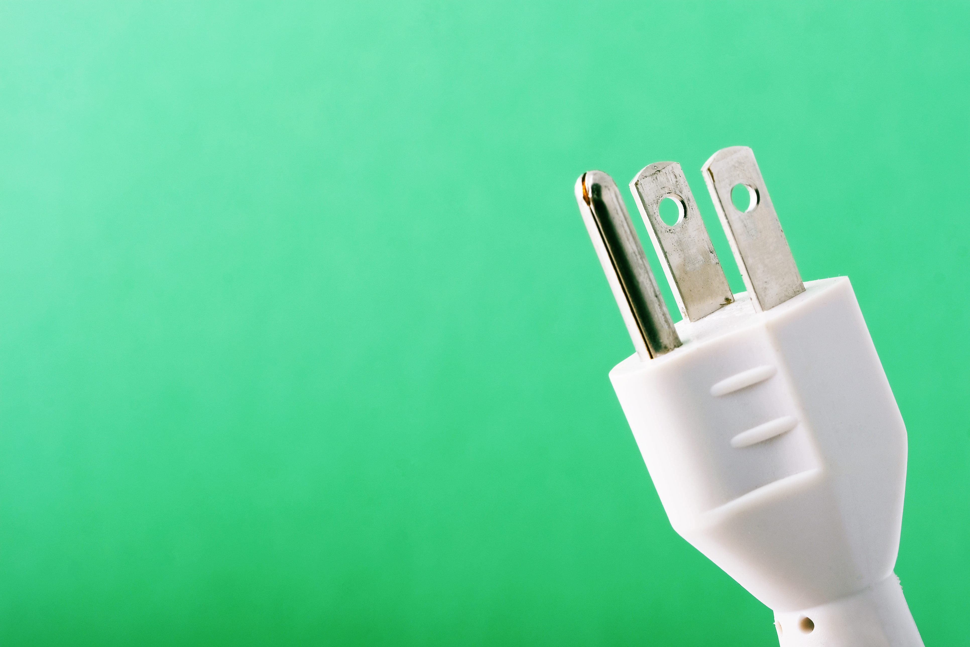 A 3-prong cord against a green background